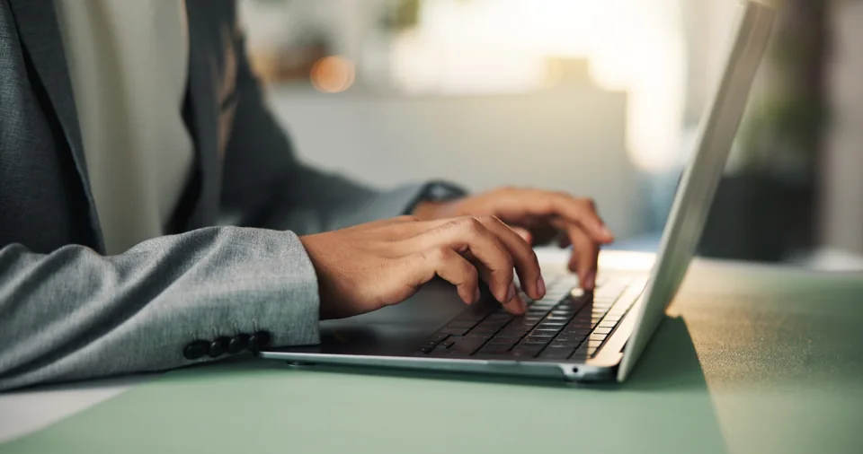 Mãos utilizando o teclado de um notebook